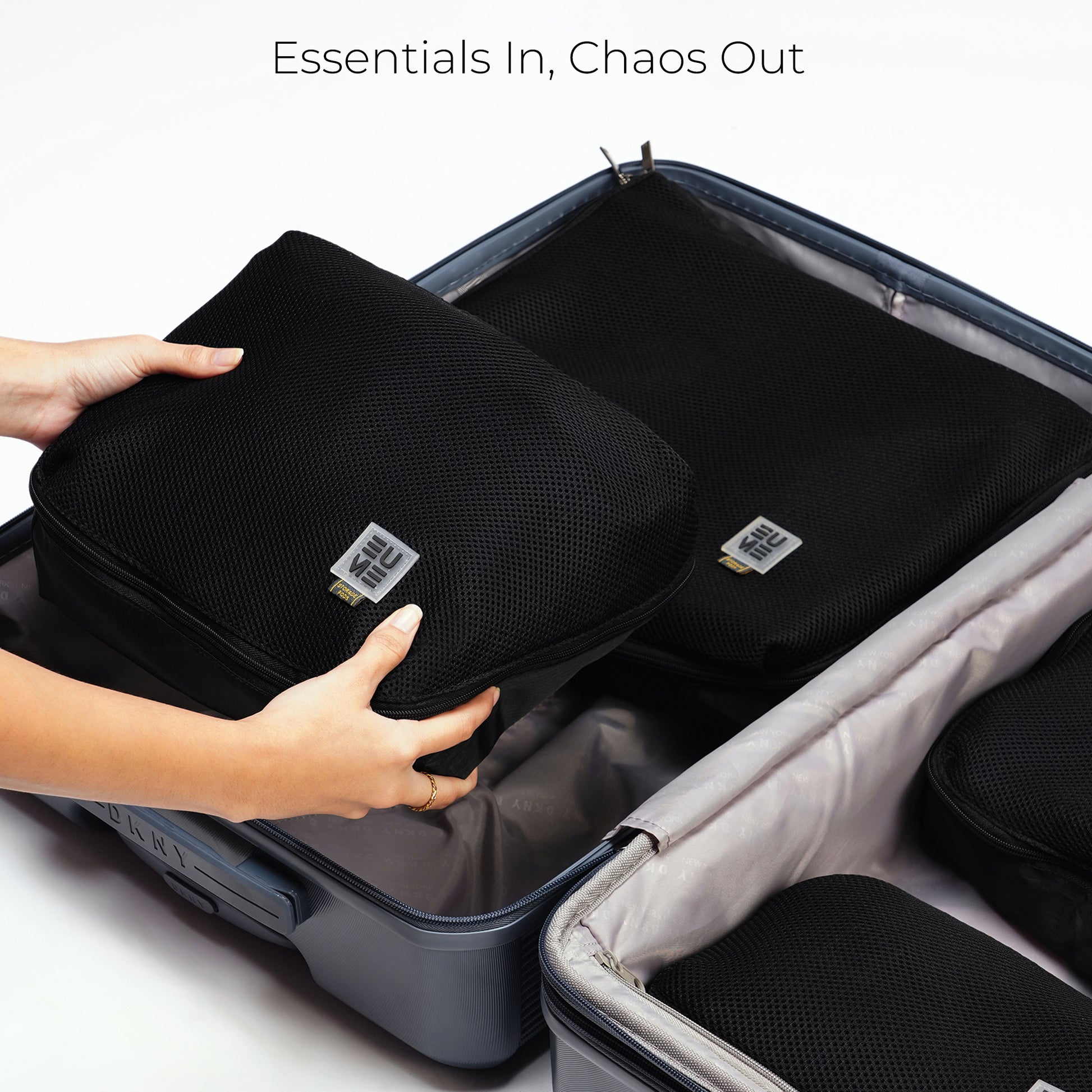 Hands placing packing cubes into a suitcase for organized travel.