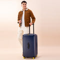 Stylish model with navy trunk suitcase for travel.