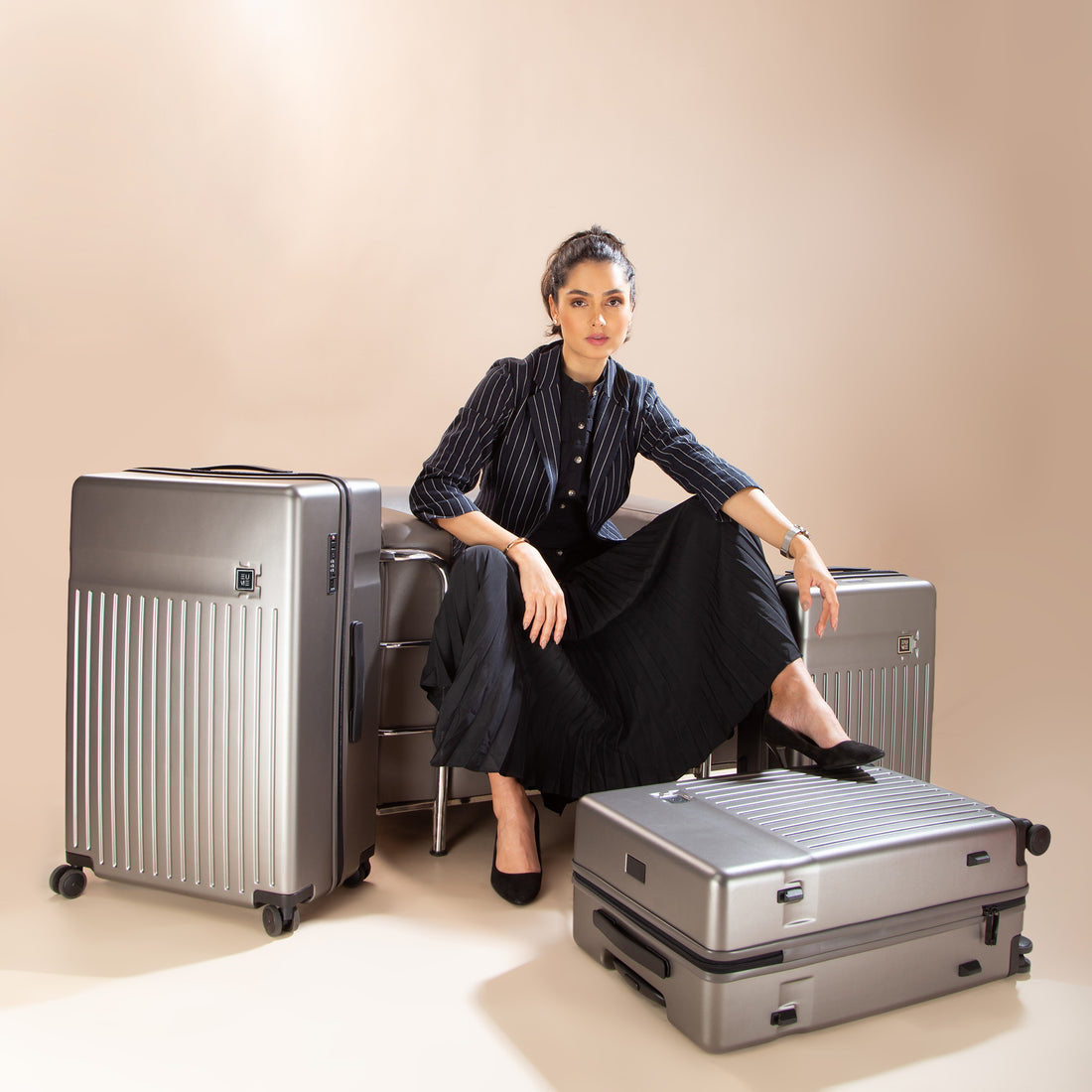 Three grey hard-shell suitcases in varying sizes with wheels.