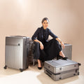 Stylish woman with classic set of 3 silver suitcases.