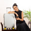 Stylish woman with Aluminium Cabin luggage and headphones.