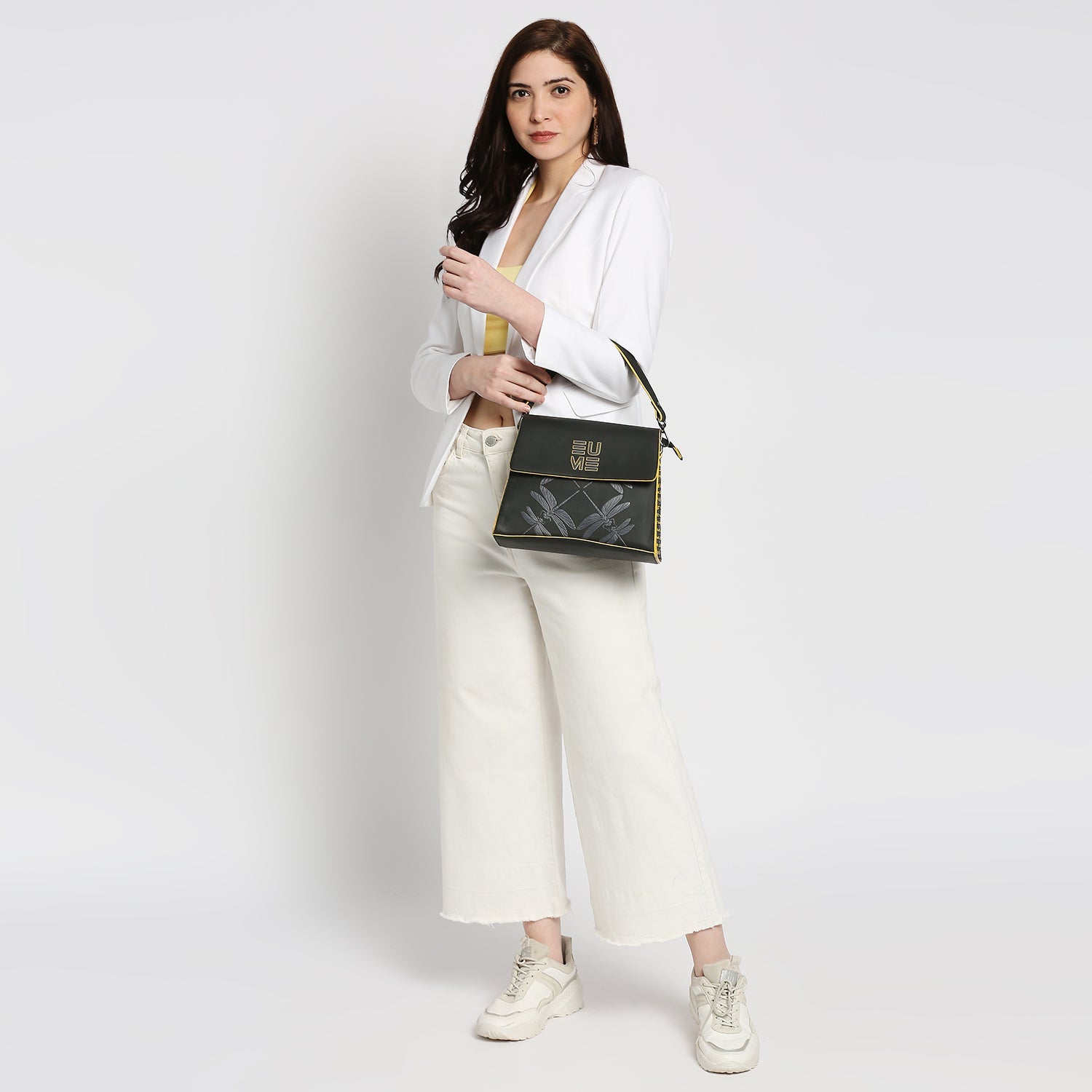 Stylish woman holding Spike-tail Satchel Handbag in contemporary outfit.