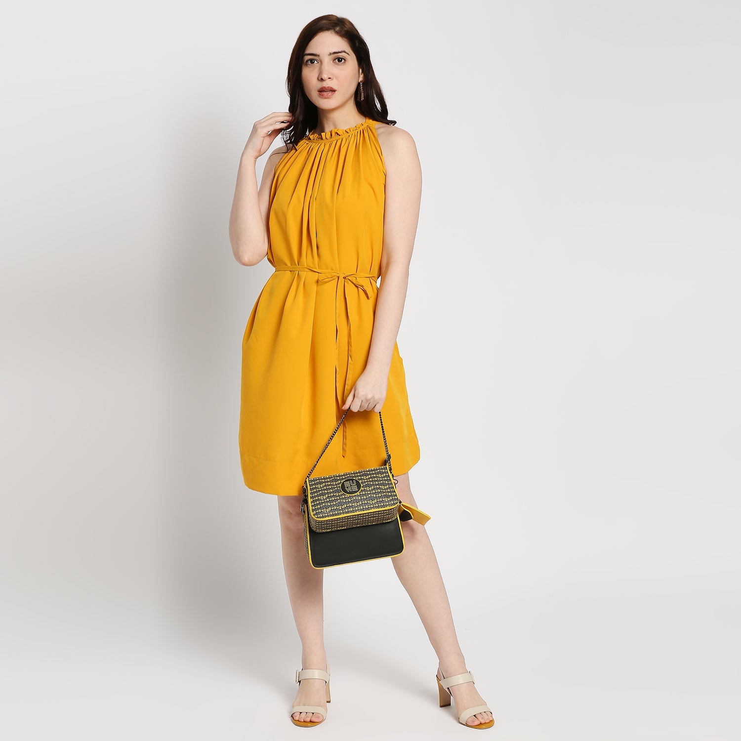 Damsel Saddle 2-in-1 detachable handbag worn with a yellow dress.