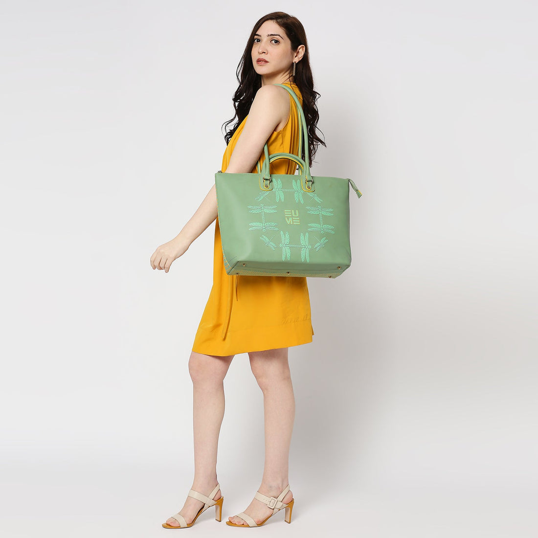 Broadwing Laptop Handbag in green with dragonfly design on yellow background.