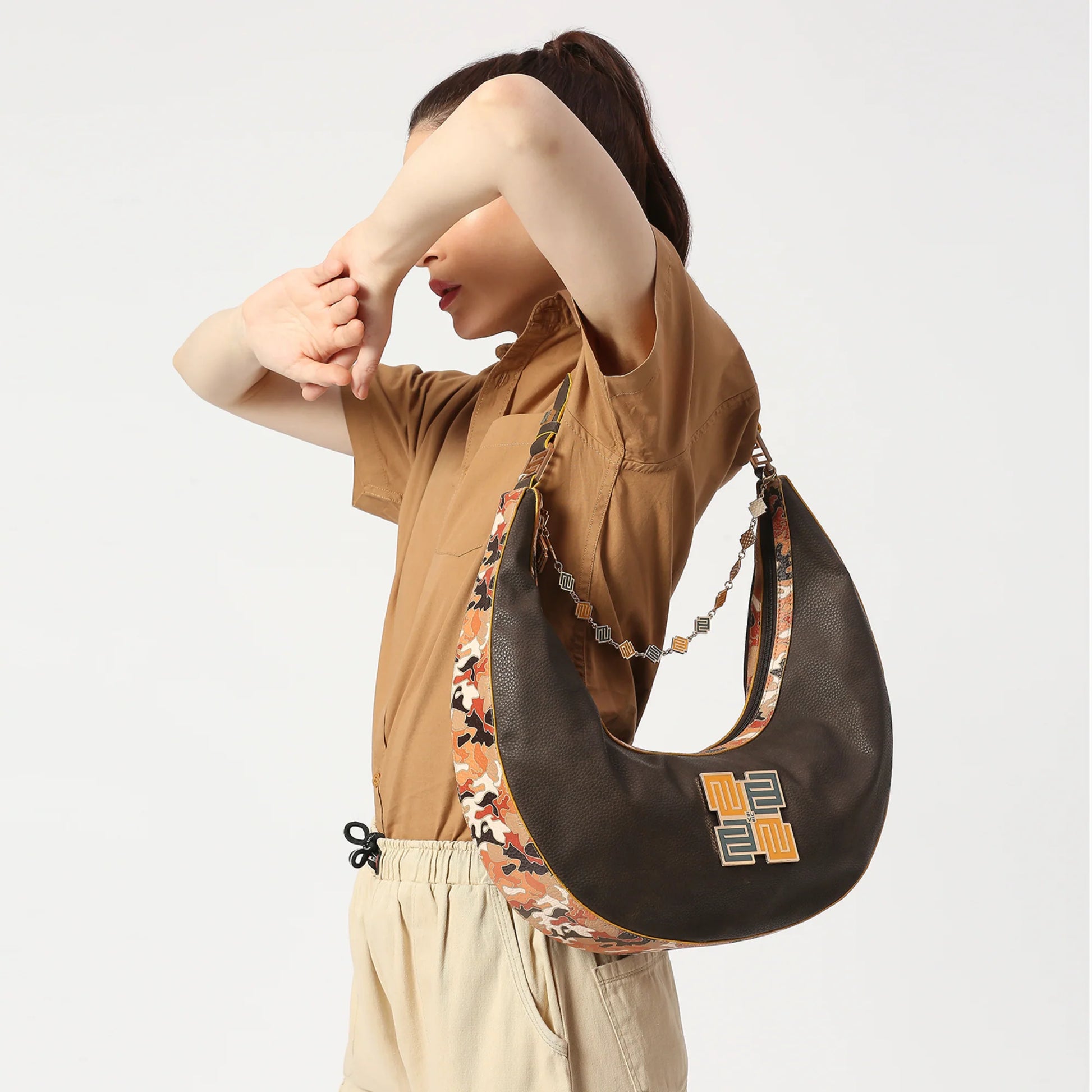 Cinnamon Hobo Bag stylishly worn by model against neutral background.