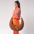 Cinnamon Hobo Bag worn by model in stylish outfit.