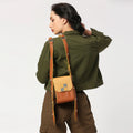 Mocha satchel bag worn casually with stylish green jacket.