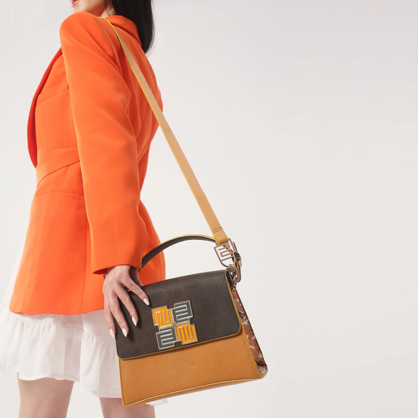 Stylish woman holding Espresso Satchel Bag with orange blazer.