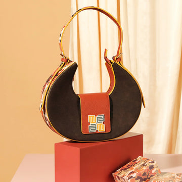 Chic chestnut saddle bag showcased on a stylish pedestal.