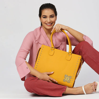 Daffodil Satchel Laptop Handbag in vibrant yellow held by a smiling model.