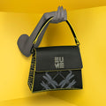 Spike-tail Satchel Handbag in black and yellow against a vibrant backdrop.