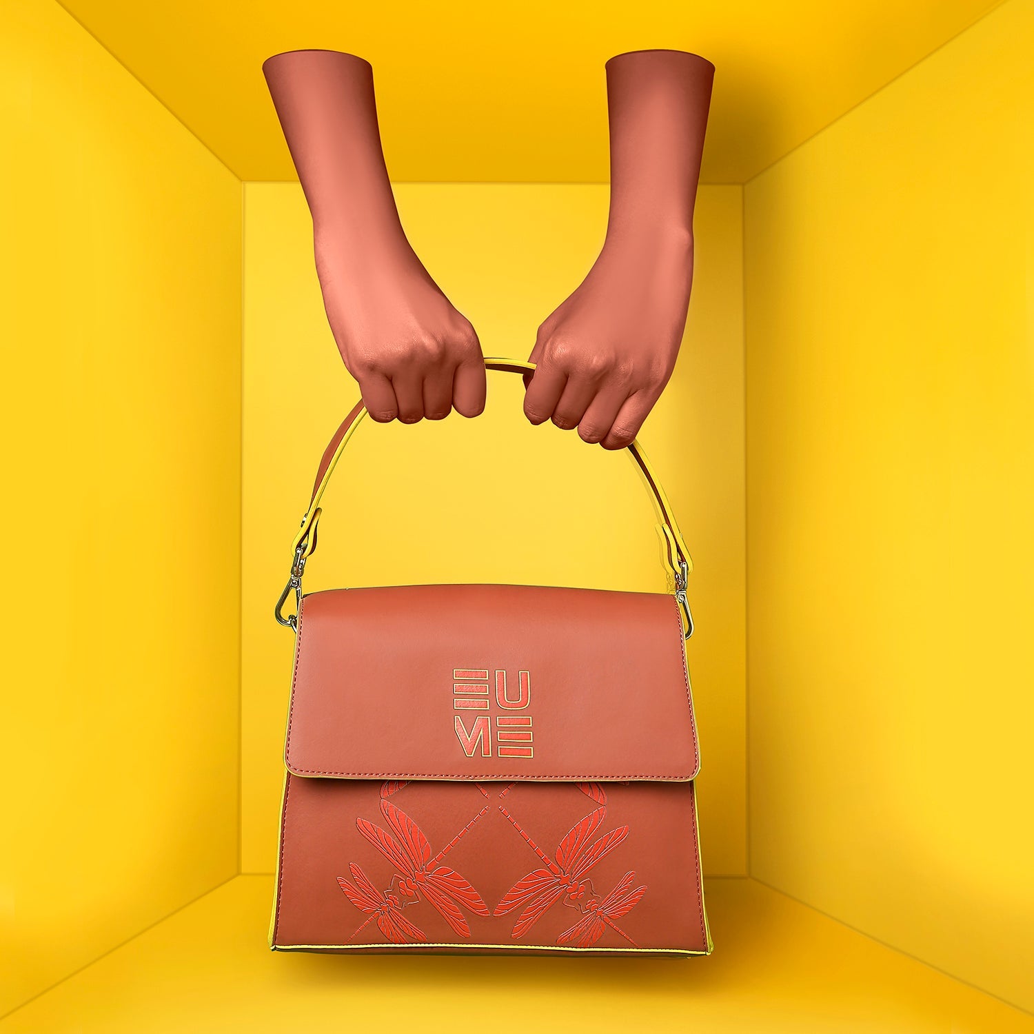 Spike-tail Satchel Handbag in hands against bright yellow backdrop.