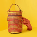 Stylish Picassu cosmetic bag on a bright yellow background.