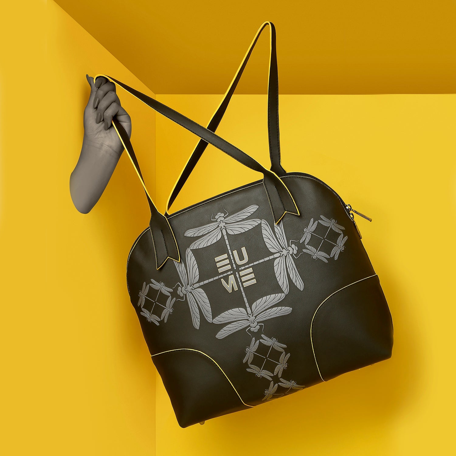 Luna Bowling Handbag hanging against bright yellow background.