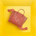 Spreadwing Tote Handbag with floral design on a bright yellow background.