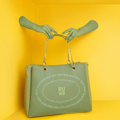 Green Flapper Laptop Handbag being held against a vibrant yellow background.