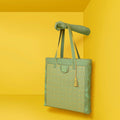 Stylish green Cruiser Shoppers Handbag displayed against a vibrant yellow background.