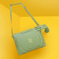 Stylish Dasher Laptop Sleeve in green, featured against a vibrant yellow background.