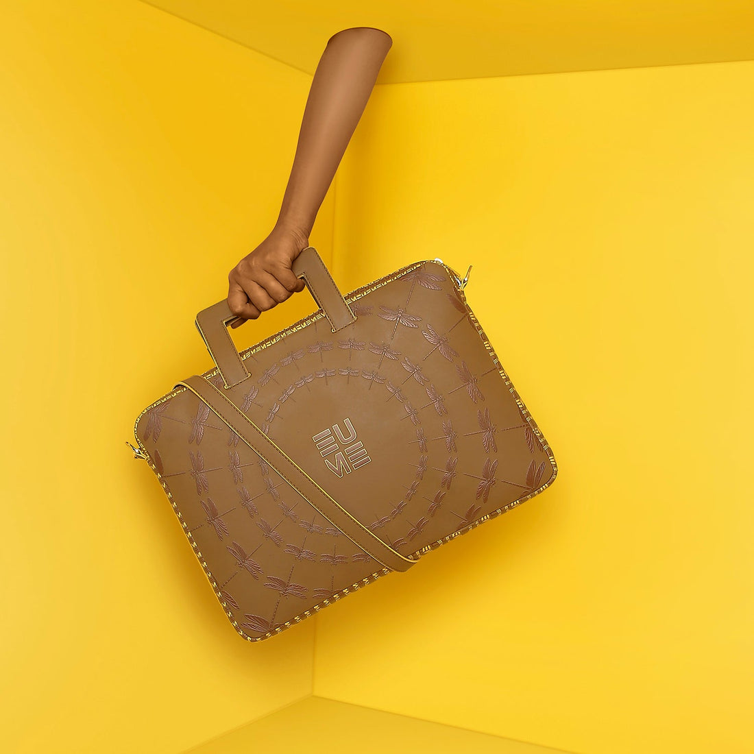 Stylish brown Dasher laptop sleeve against a bright yellow background.