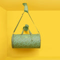 Chopper Duffel Bag in mint green displayed against a vibrant yellow background.